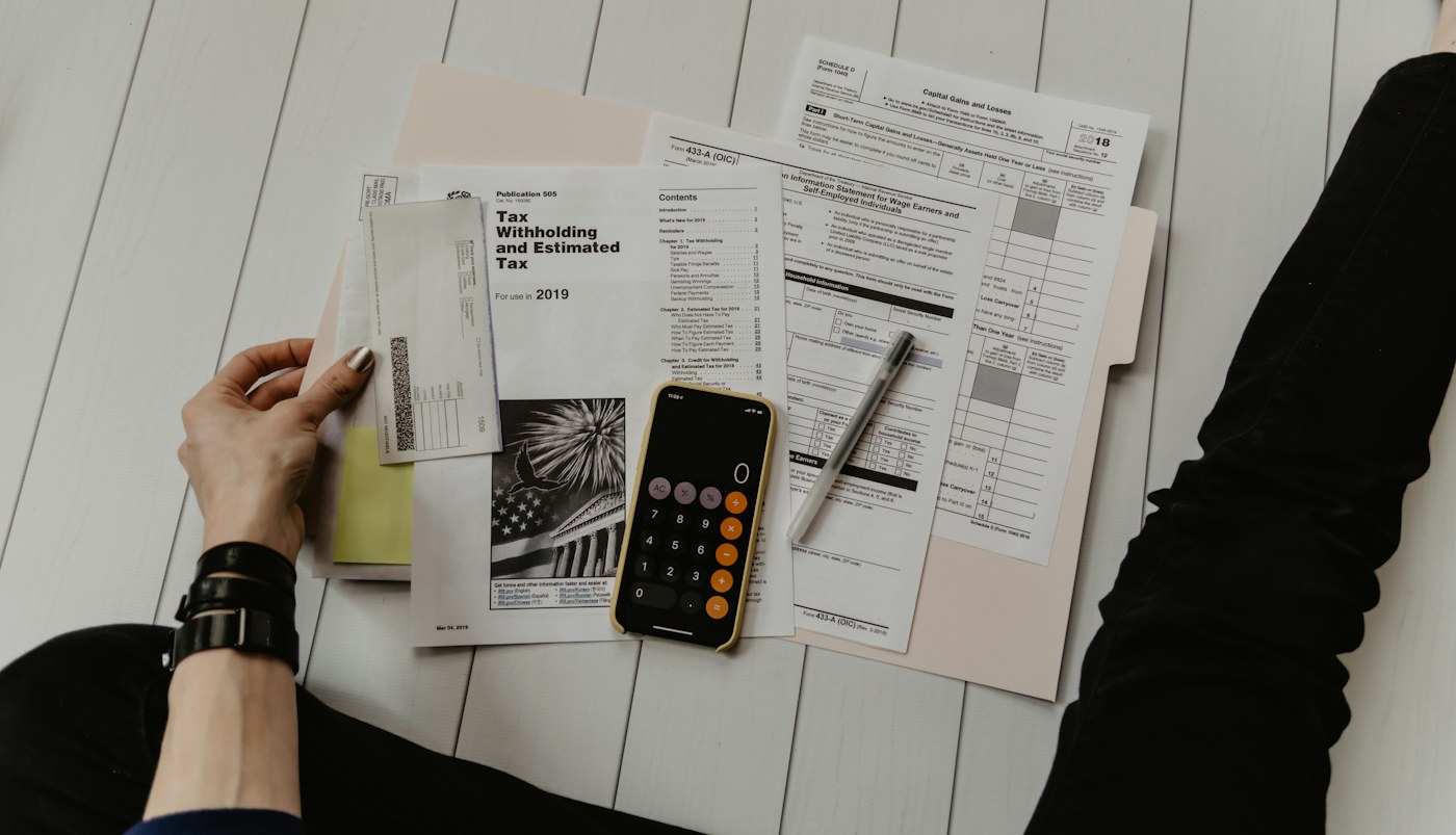 Hands sorting bills and using a calculator at home